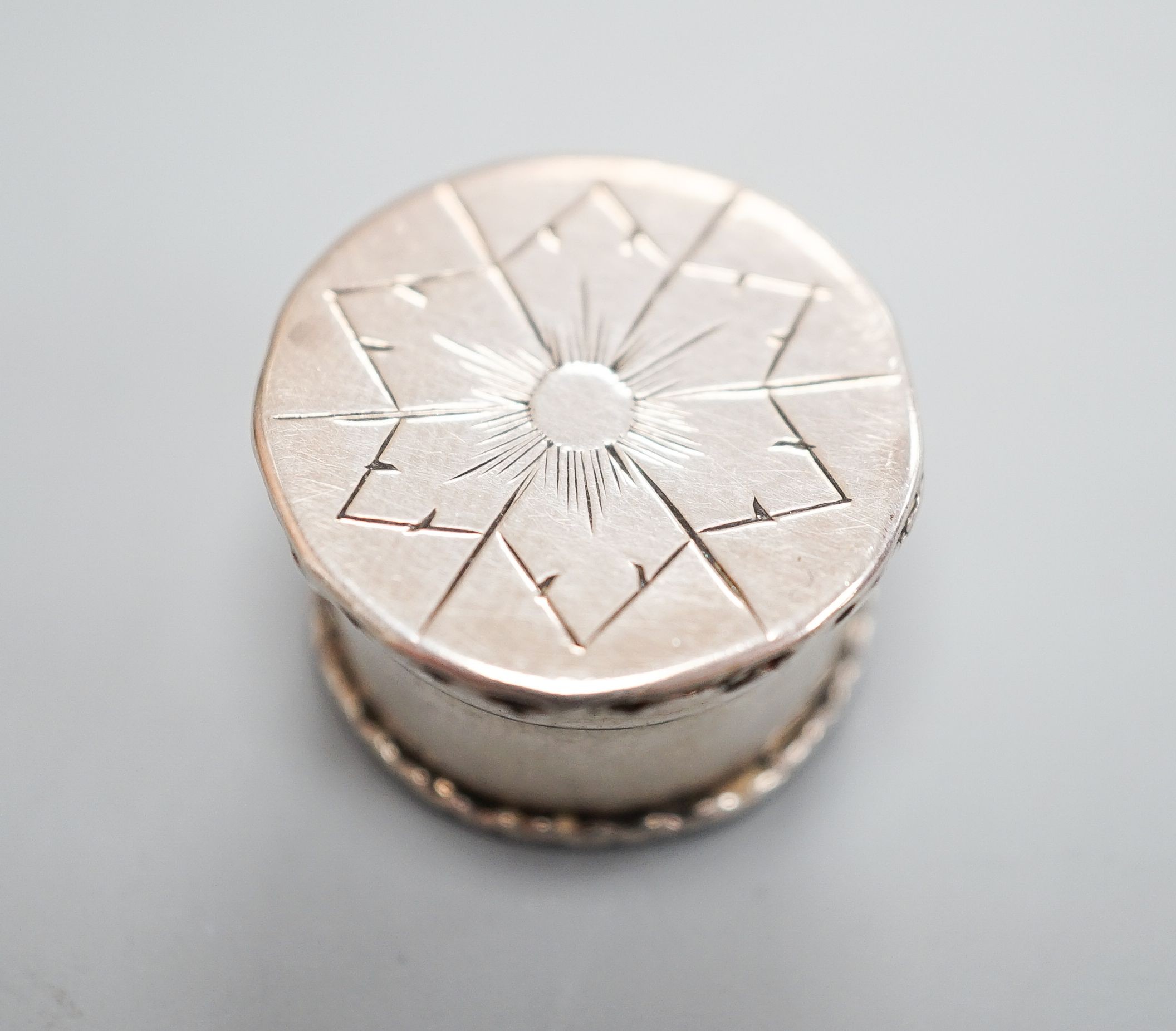 A mid 18th century German? small pill box, with engraved flower head decoration, 19mm.